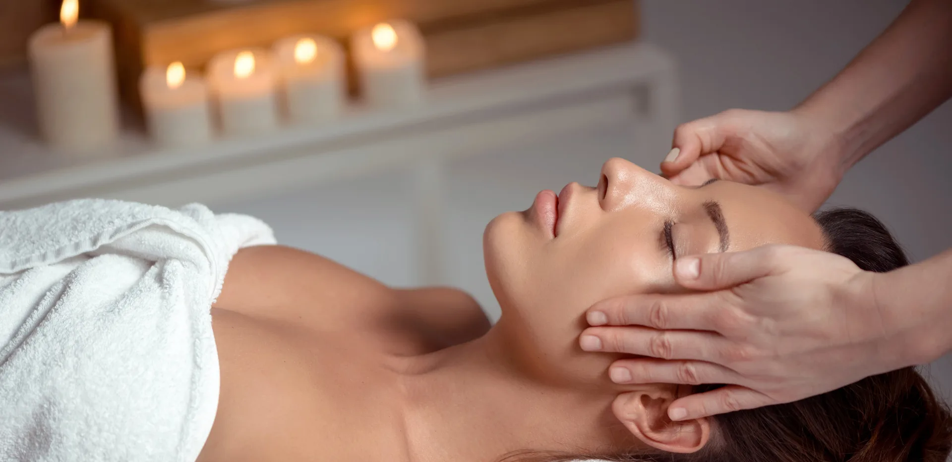 Massage du visage aux bougies pendant un soin personnalisé