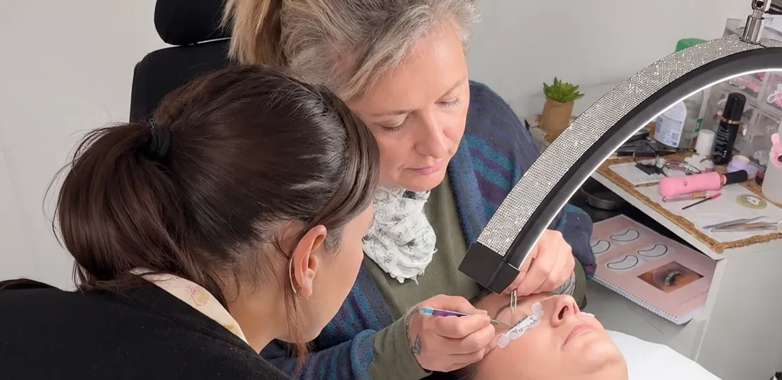 Pose d'extensions de cils sur modèle réel pendant la formation