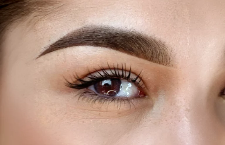 gros plan d'un œil marron, sourcil dense au tracé net et dégradé : résultat d'un maquillage permanent