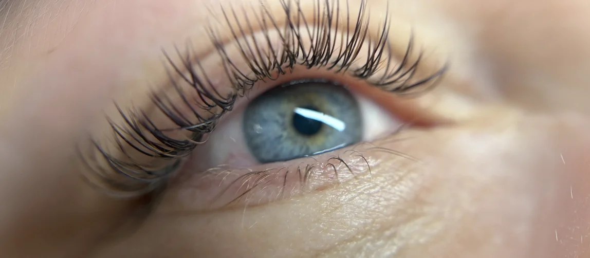 Gros plan d'un œil bleu aux extensions de cils longues et recourbées